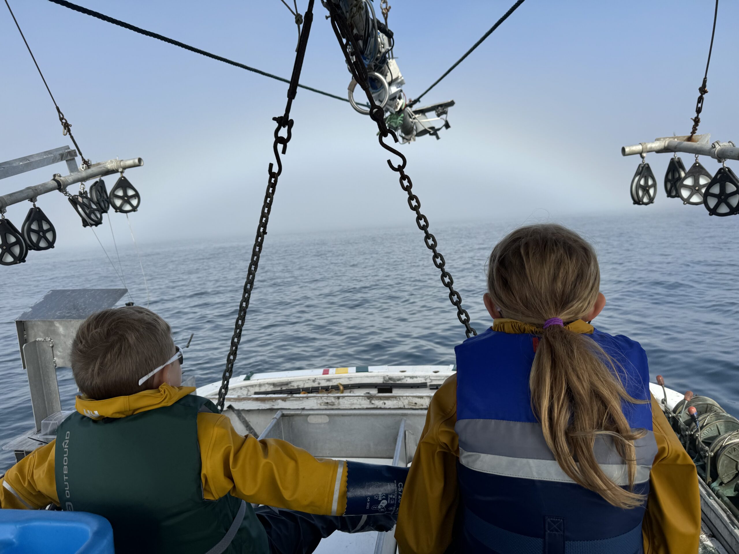 Two children gaze upon the ocean from a boat